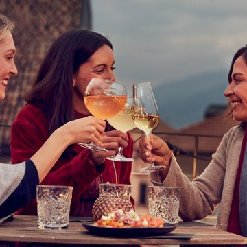 Gudruns Blog: alles über Sterzing, übers Wandern, über Tirol Drei Frauen stoßen mit Weingläsern bei einem Treffen im Freien an