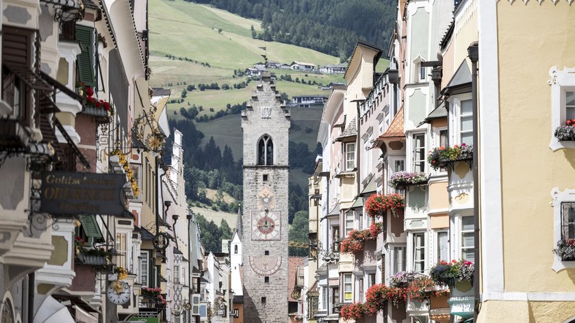 Südtirols Städte Historischer Turm und farbenfrohe Häuser in einer alpinen Stadt
