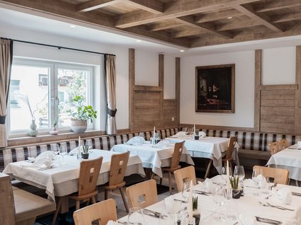 Gudrun in Gossensass: hotel with heart Elegant restaurant with wooden furniture and white table settings