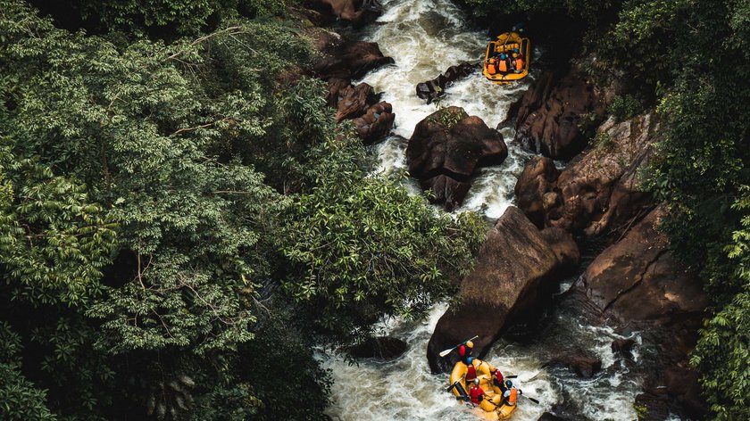 Wildwasserabenteuer in Südtirol Zwei Boote mit Menschen auf einem wilden Fluss in einem dichten grünen Wald