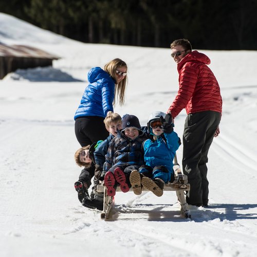 The Ladurns ski area and other winter highlights Family sledding on snowy path in winter