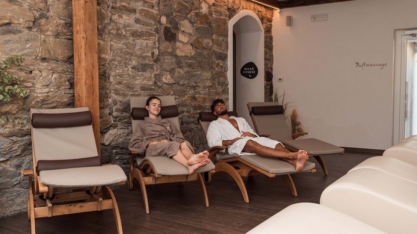 Il mese preferito di Gudrun Due persone rilassate su lettini in una stanza relax di una spa con muro in pietra