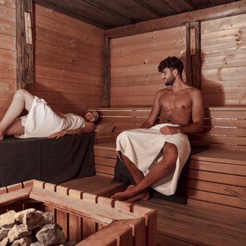 Gudruns Blog: alles über Sterzing, übers Wandern, über Tirol Mann und Frau entspannen in einer finnischen Sauna mit Holzverkleidung