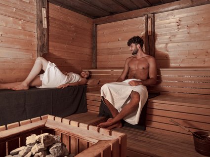 Explorer and wellness hotel near Sterzing Man and woman relaxing in a wooden Finnish sauna