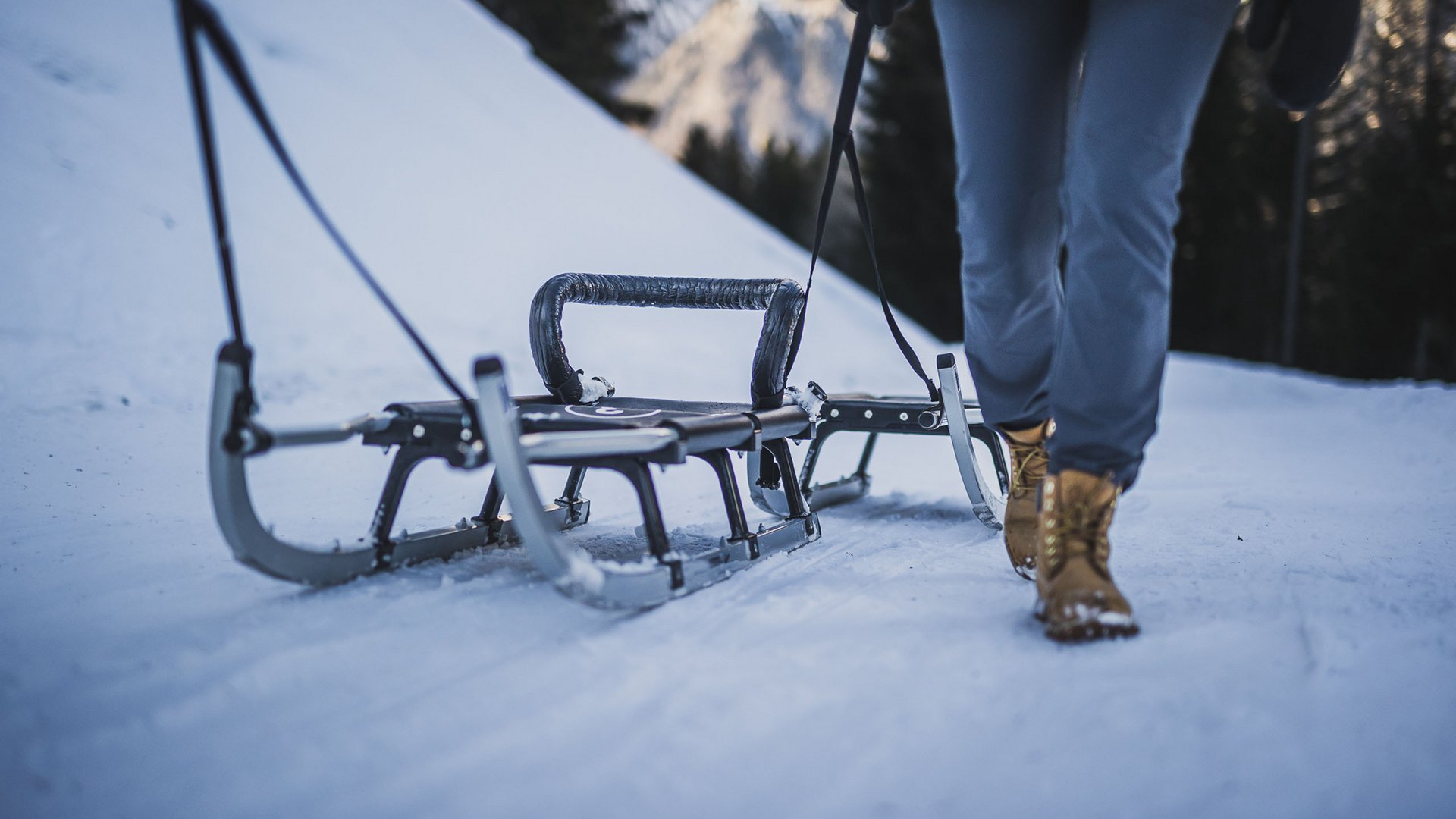 Accommodation near Ladurns for families Person pulling a racing sled on a snowy track
