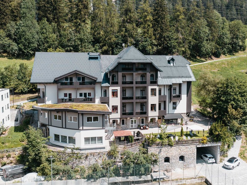 Gudrun in Gossensass: Hotel mit Herz Großes Haus in Alpenlandschaft mit Garten und Wald im Hintergrund