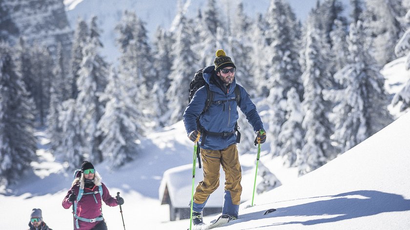 Gioia invernale Tre persone che camminano con le ciaspole in montagna innevata