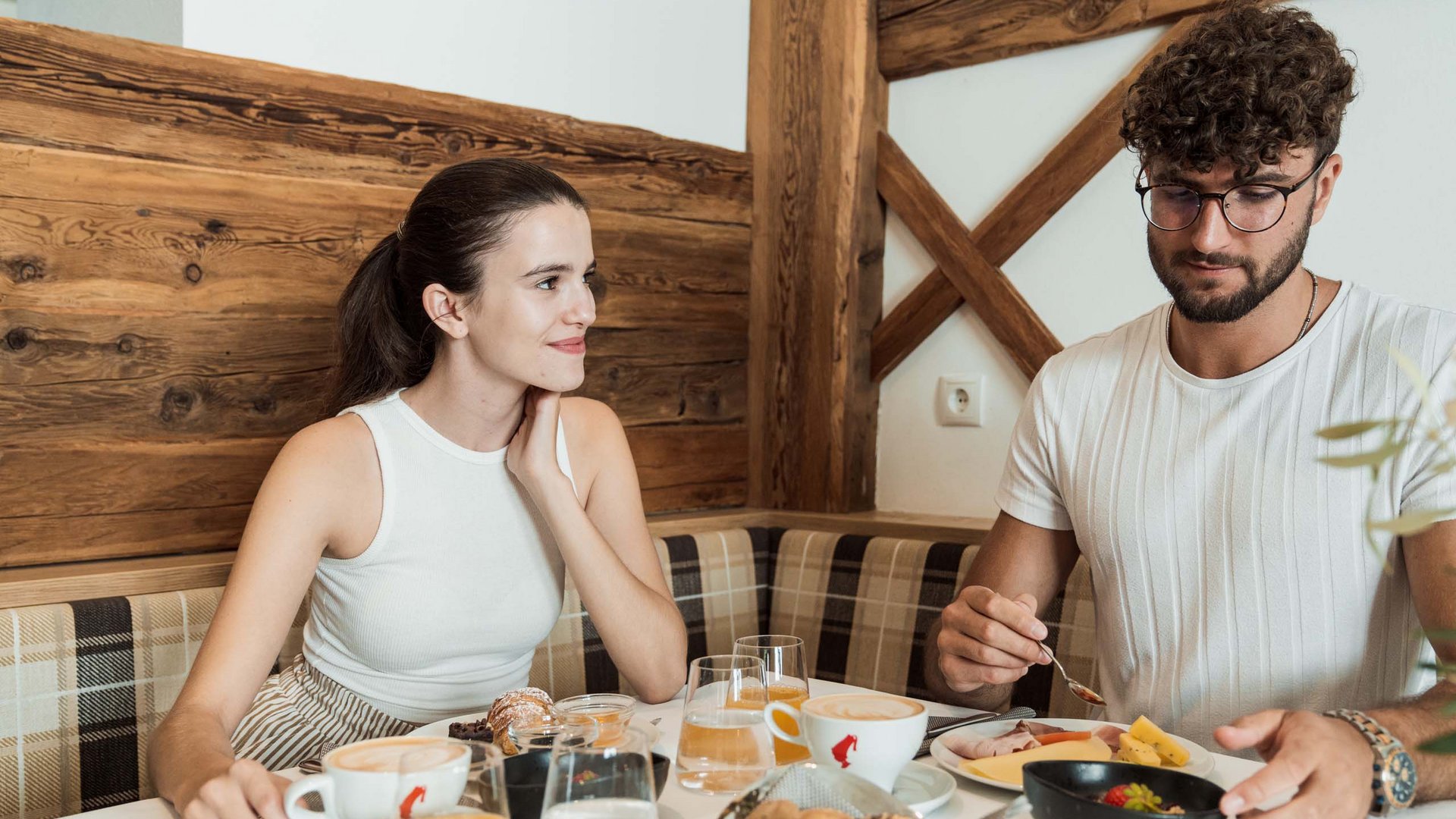 Eines der coolsten Hotels in Gossensass (Südtirol) Paar genießt Frühstück mit Kaffee, Saft und Gebäck in gemütlichem Ambiente