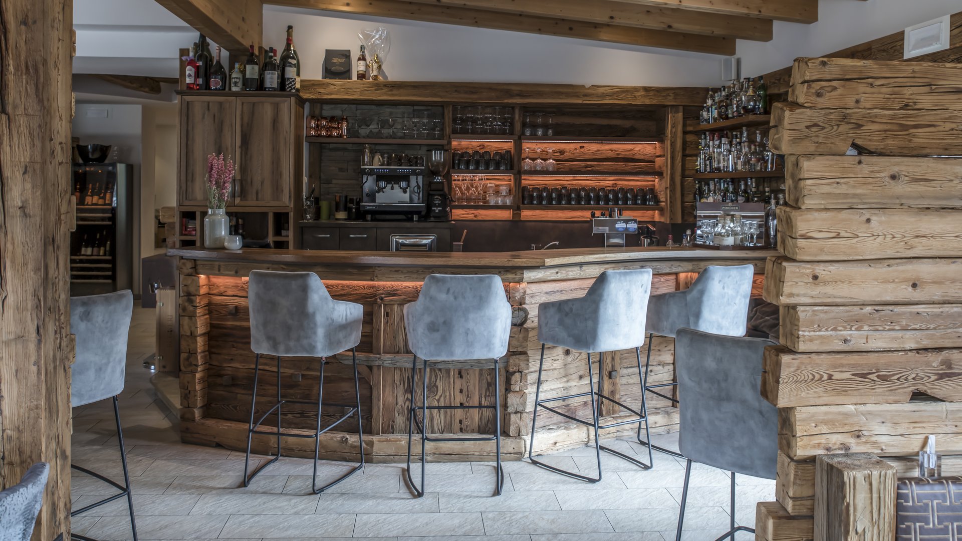 Gudrun in Gossensass: hotel with heart Cozy bar with wooden counter and gray bar stools in rustic style