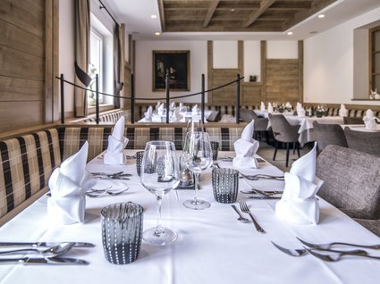 Gudrun in Gossensass: hotel with heart Elegant restaurant with set tables and plaid bench seating