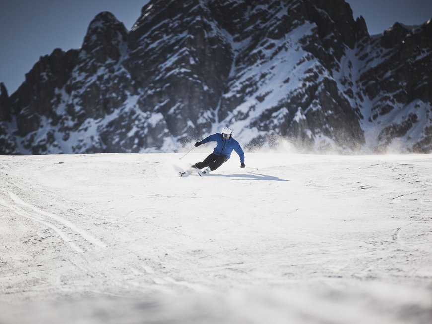 The Ladurns ski area and other winter highlights Skier in blue jacket skiing on snow with rugged mountain backdrop
