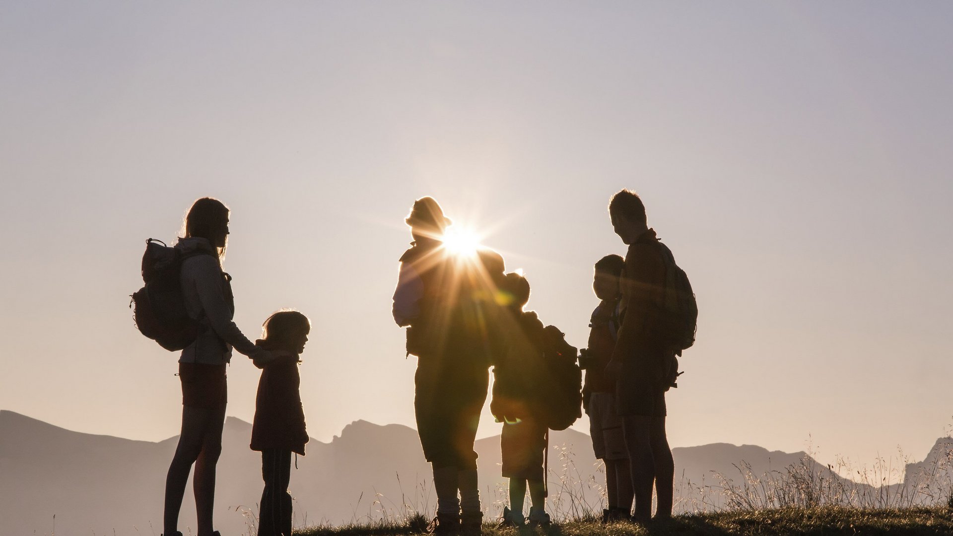 Hotel between Brenner and Sterzing: events Silhouettes of a family with backpacks at sunset in the mountains