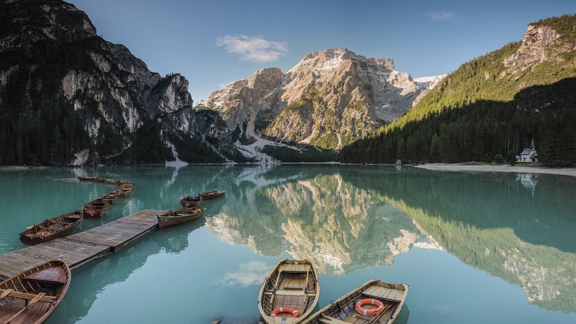 Ein Ausflug an den Pragser Wildsee Holzboote an einem Steg auf einem Bergsee mit spiegelnden Bergen und Wäldern