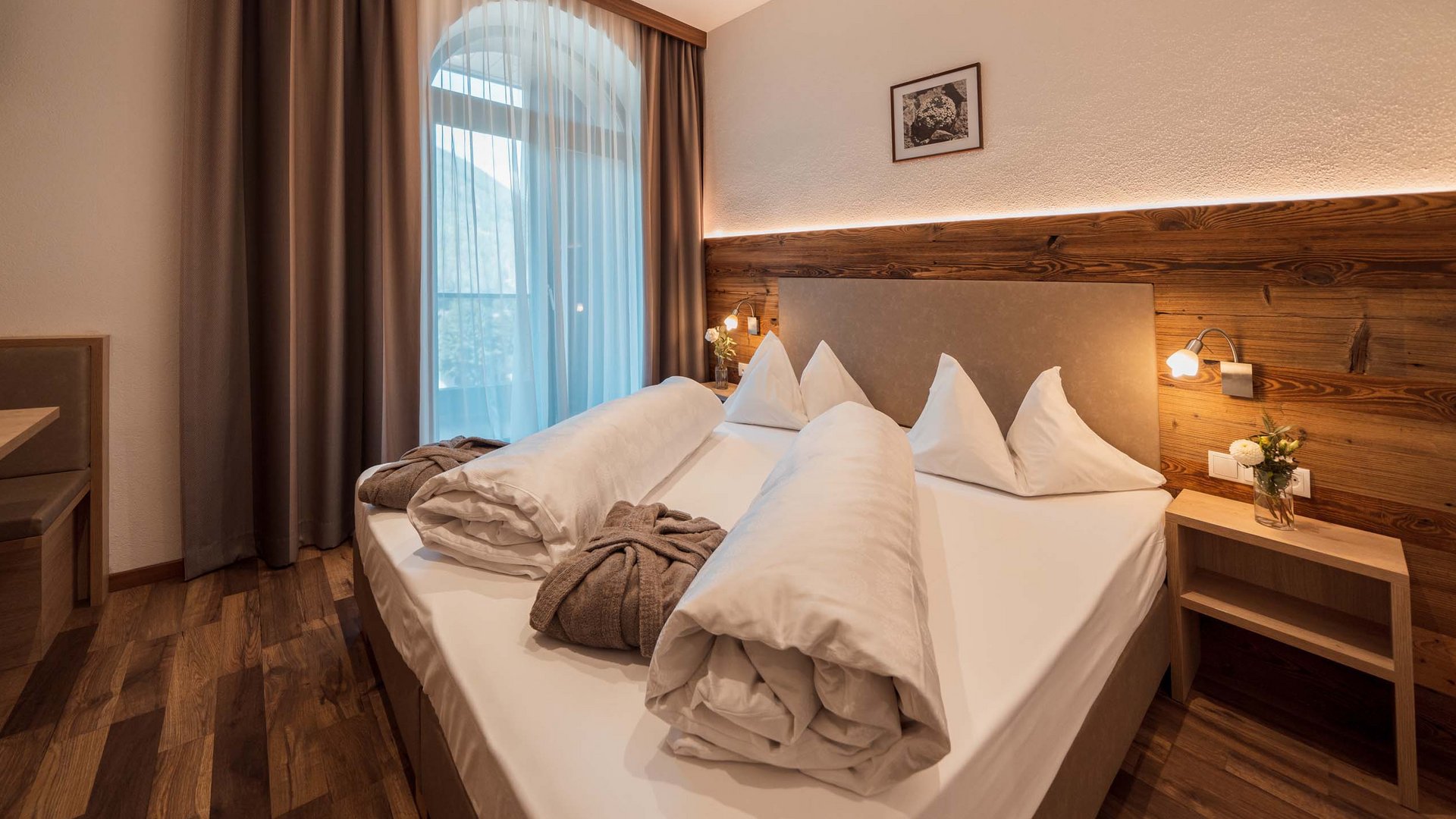 Gudrun in Gossensass: Hotel mit Herz Modernes Hotelzimmer mit Doppelbett, Holzdekor und Fenster mit blickdichten Vorhängen