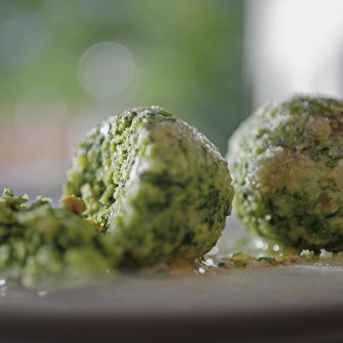 Hotel a Colle Isarco: benvenuti da Gudrun! Due canederli verdi su un piatto, uno rotto a metà