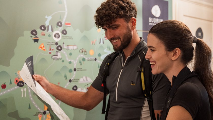 Natura in fiore Due escursionisti leggono una mappa davanti a una grande mappa a parete