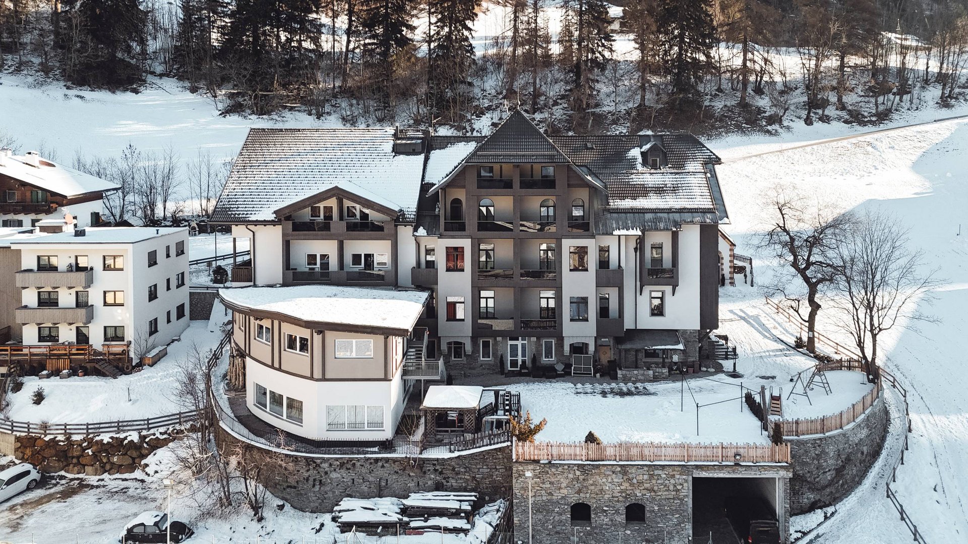 Multi-story house with snow on roof and snowy landscape