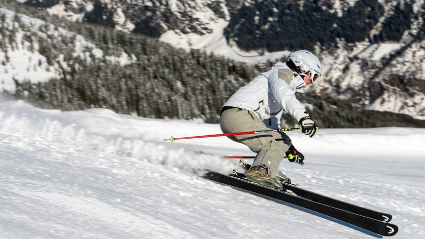 Drei auf einen Streich Person fährt Ski auf schneebedecktem Berghang bei klarem Wetter