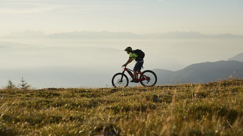 Gossensass auf zwei Rädern entdecken Mountainbiker fährt auf einem Berg mit Nebel und Bergen im Hintergrund