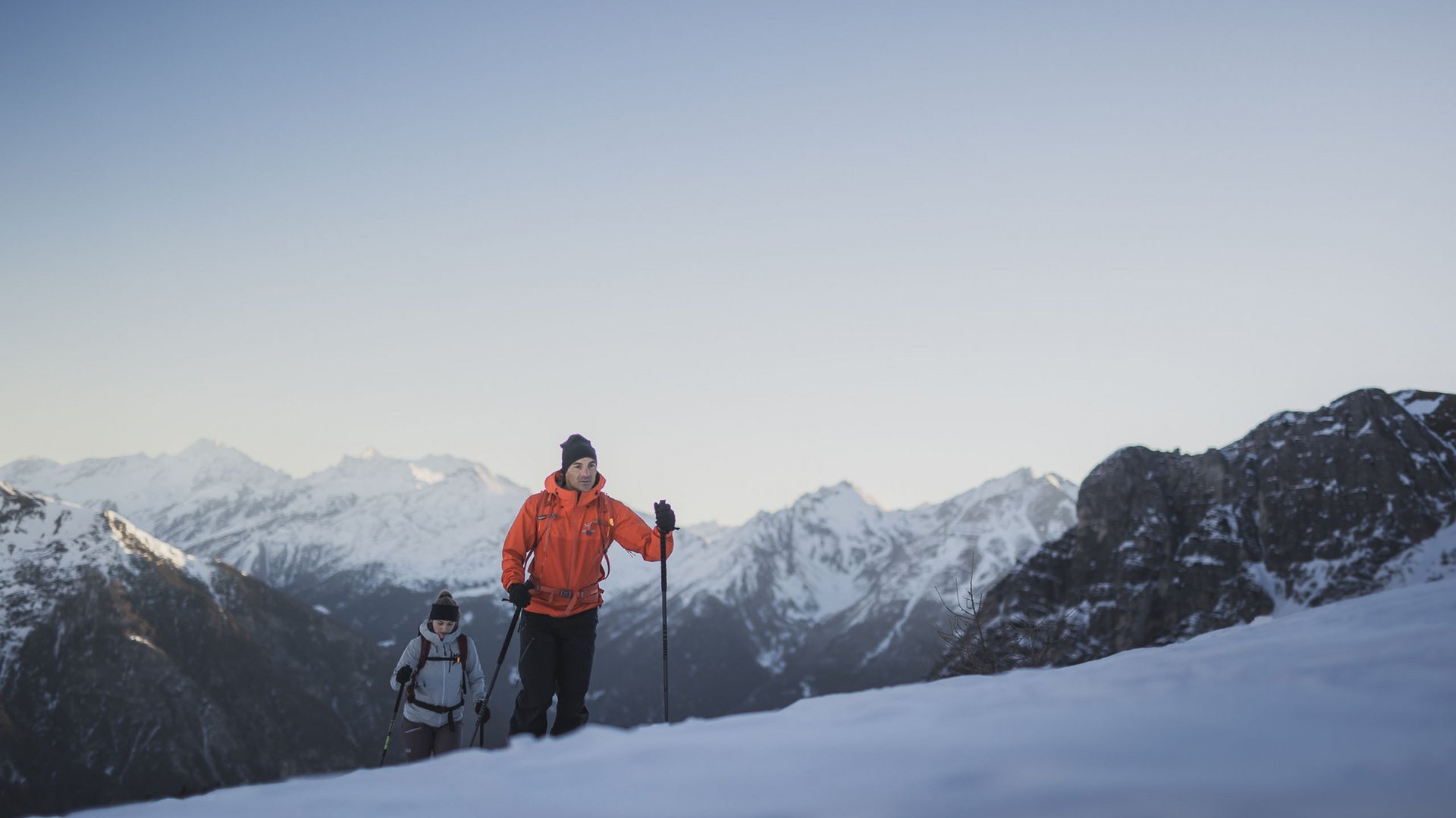 Gudrun in Gossensass: hotel with heart Two hikers with poles walking in snow with snowy mountains and clear sky in background