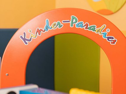 Home Arco colorato con la scritta Kinder-Paradies in una stanza giochi