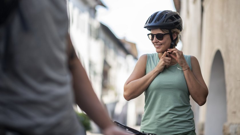 Ciclovia dell’amicizia Monaco – Venezia Donna con casco e occhiali da sole prepara la bici