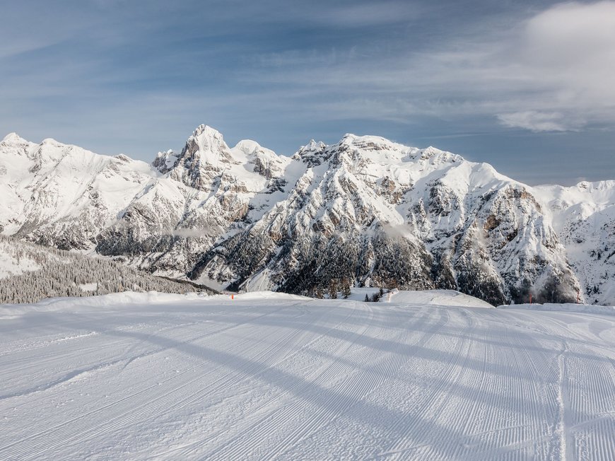 Hotel near Val di Fleres/Pflerschtal: location and arrival Freshly groomed ski slope with snowy mountains under blue sky