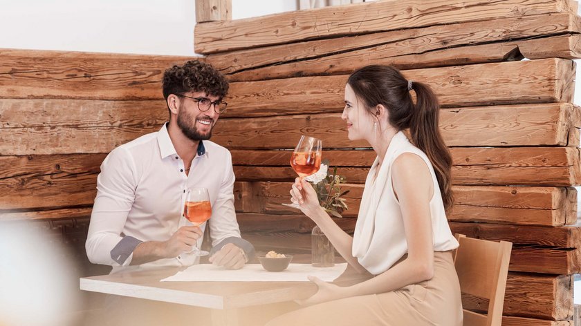 Romantik by Gudrun Junges Paar trinkt Wein und unterhält sich in einem gemütlichen Holzrestaurant
