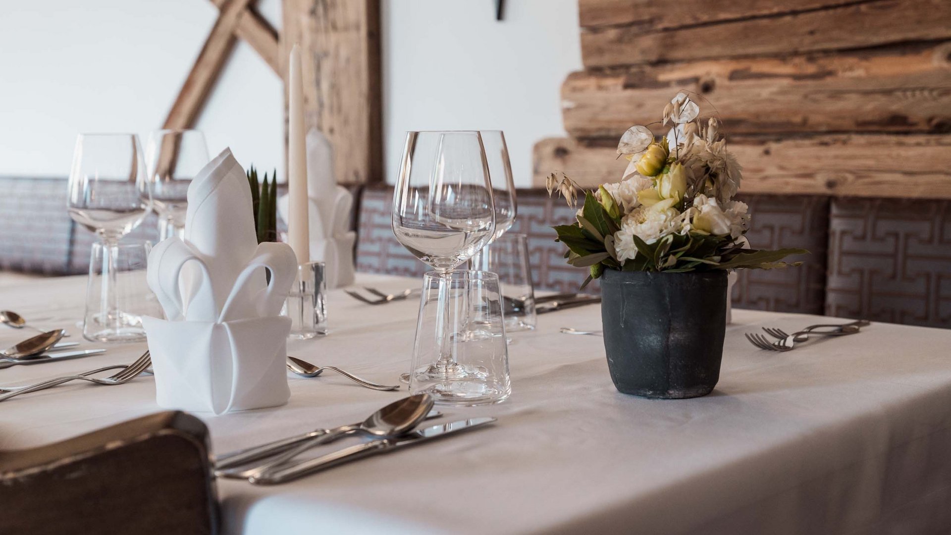 Home Tavolo apparecchiato con tovaglioli, bicchieri e composizione floreale in ristorante