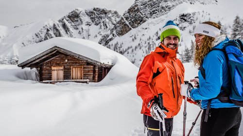 Gudrun in Gossensass: Hotel mit Herz Zwei Skifahrer mit Stöcken vor verschneiter Hütte in den Bergen