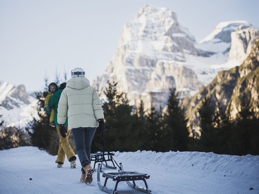 Hotel a Colle Isarco: benvenuti da Gudrun! Persona che trascina una slitta su sentiero innevato con montagna sullo sfondo