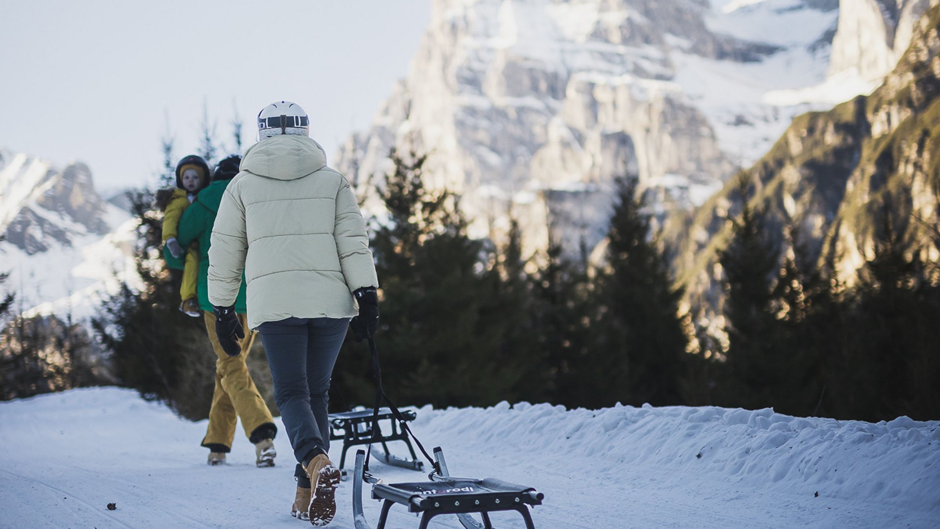 Accommodation near Ladurns for families Person pulling sled on snowy path with mountain in the background