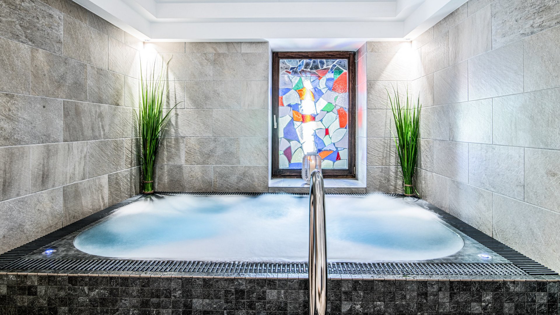 Gudrun in Gossensass: hotel with heart Modern hot tub with stained glass window and plants in a spa room