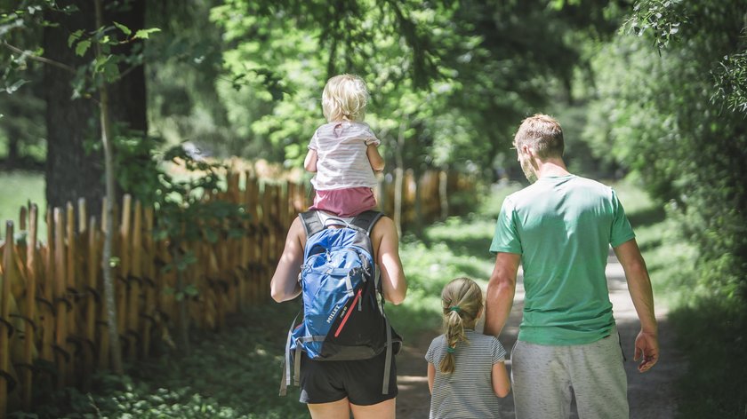 Die schönsten Familienrouten rund um Gossensass Familie mit zwei Kindern wandert auf einem Waldpfad im Sommer