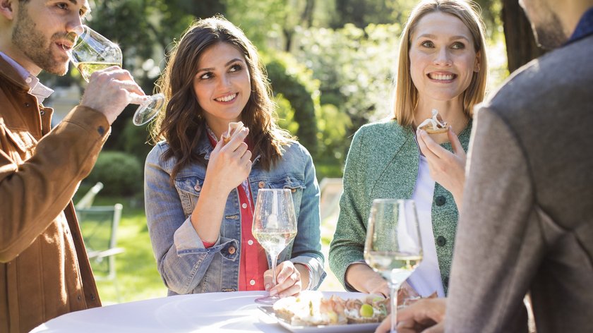 Le dritte di Gudrun Quattro persone all'aperto bevono vino e mangiano stuzzichini