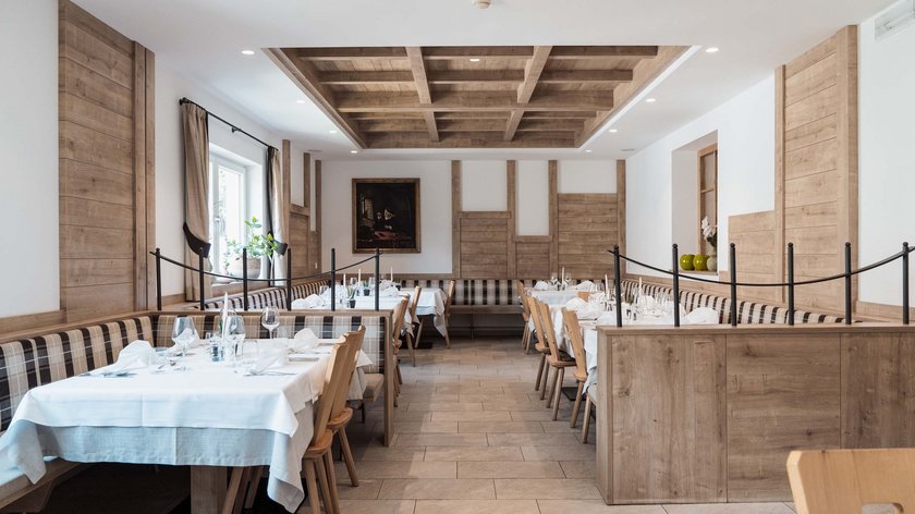 Gudrun ai fornelli: tirtlen al quark Ristorante luminoso con dettagli in legno, tavoli apparecchiati e panche a quadri