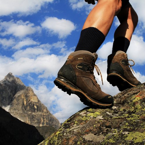 Hiking in Sterzing and the surrounding area Hiker wearing brown hiking boots on rocky terrain with mountain background