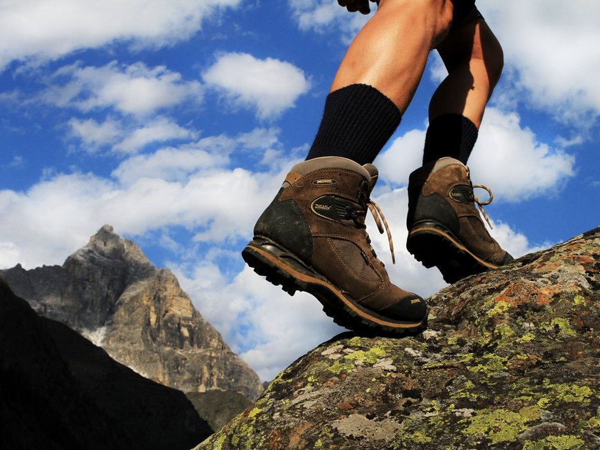Hotel a Colle Isarco: benvenuti da Gudrun! Escursionista con scarpe da trekking marroni su roccia davanti a montagna