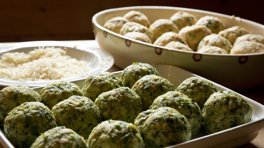 Gudrun ai fornelli: ricetta dei canederli alle ortiche Canederli freschi di spinaci in ciotole su tavolo di legno