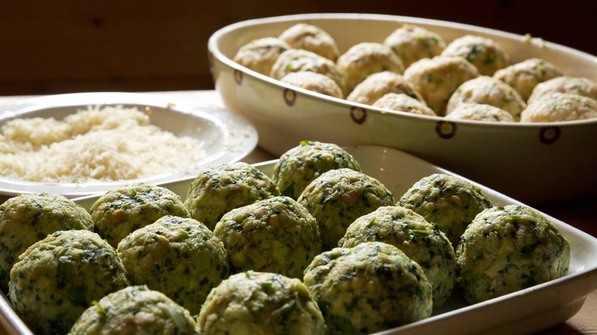 Gudrun ai fornelli: ricetta dei canederli alle ortiche Canederli freschi di spinaci in ciotole su tavolo di legno