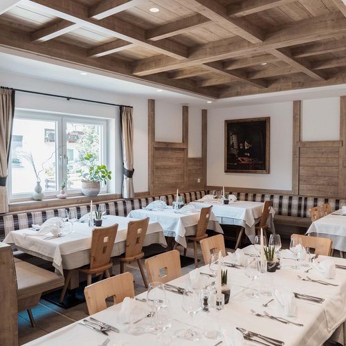 Gudrun's holiday apartments: real freedom on holiday Stylish dining room with wooden beam ceiling and tables set with white tablecloths