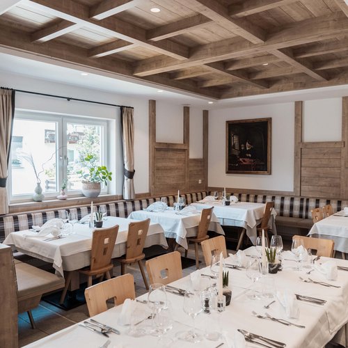 Gudrun's holiday apartments: real freedom on holiday Stylish dining room with wooden beam ceiling and tables set with white tablecloths